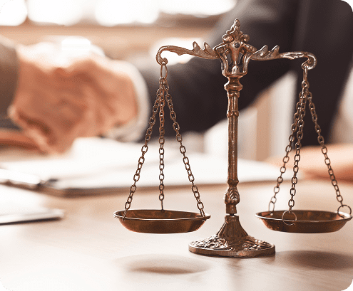 Scales of justice with handshake background.