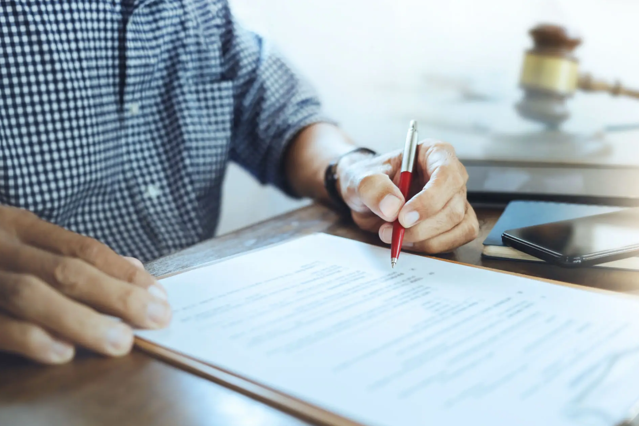 Person marking answers on a paper with a red pencil.