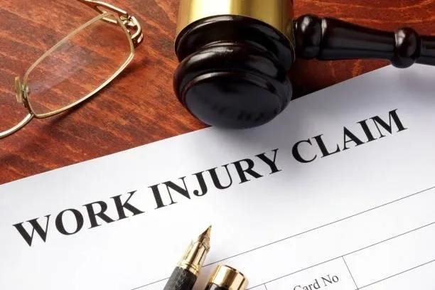 Gavel and pens on a work injury claim document.