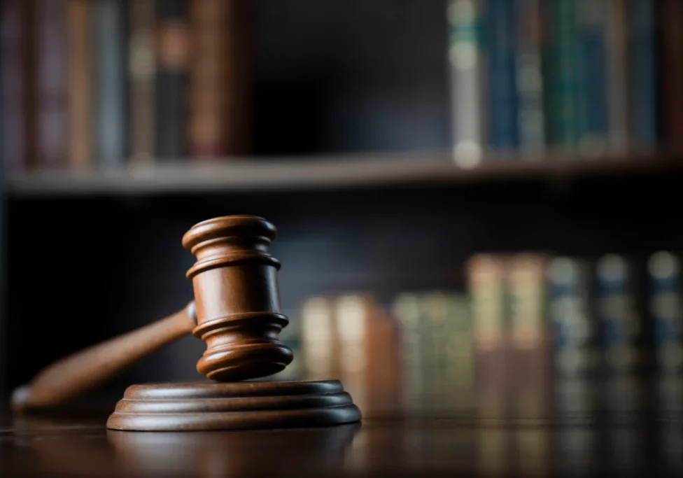 Gavel on desk with blurred books background.